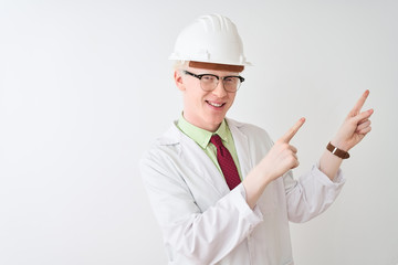 Albino scientist man wearing glasses and helmet standing over isolated white background smiling and looking at the camera pointing with two hands and fingers to the side.