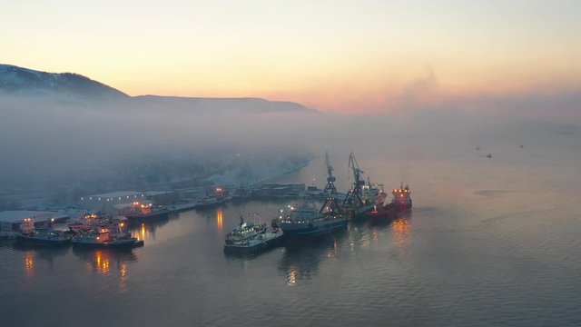 Early in the morning at dawn in the fog, the ships are in port, video from the quadrocopter
