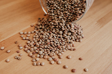 healthy eco-friendly dry group of buckwheat or peas scattered from glass dishes on a light wooden table, cooking vegetarian food