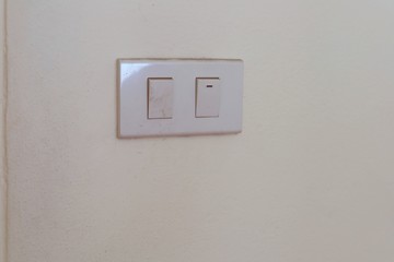 White electrical switch plate on the wall for control the light turning on or off.