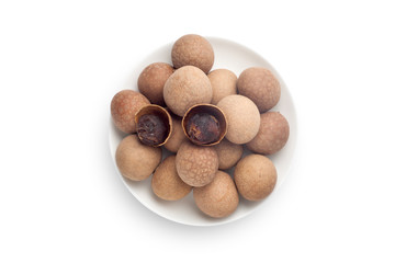 Dried longan in a white plate, Isolated on white background. Top view.
