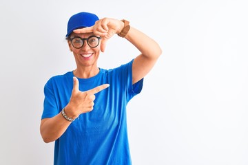 Senior deliverywoman wearing cap and glasses standing over isolated white background smiling making frame with hands and fingers with happy face. Creativity and photography concept.