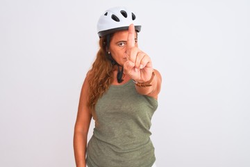 Middle age mature cyclist woman wearing safety helmet over isolated background Pointing with finger up and angry expression, showing no gesture