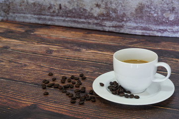 Cappuccino in white coffee cup on wooden table with dark roasted coffee bean