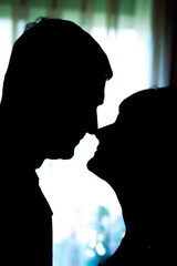 Two silhouettes of lovers. Bride and groom on a light background.