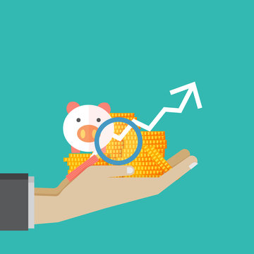 Hand hold Money saving piggy and magnification glass ,investment and saving concept on green