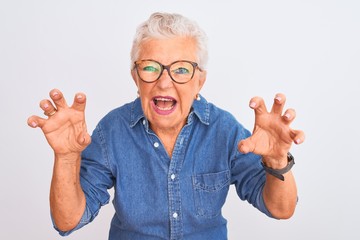 Senior grey-haired woman wearing denim shirt and glasses over isolated white background smiling...