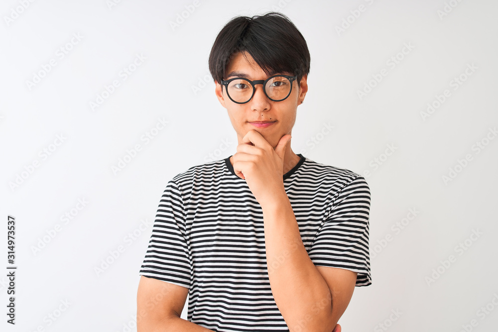 Sticker Chinese man wearing glasses and navy striped t-shirt standing over isolated white background looking confident at the camera with smile with crossed arms and hand raised on chin. Thinking positive.