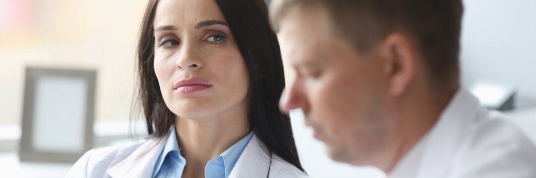 Woman Dissatisfied Doctor Distrust Looks At Her Colleague Portrait. Incorrect Treatment Concept