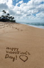 Happy Valentine’s Day with a heart drawn in the sand 