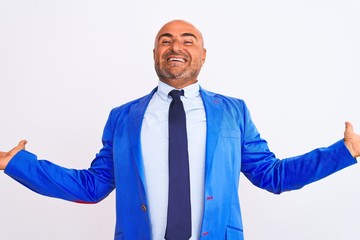 Middle age businessman wearing suit standing over isolated white background smiling showing both hands open palms, presenting and advertising comparison and balance