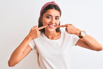 Young beautiful woman wearing casual t-shirt and diadem over isolated white background smiling cheerful showing and pointing with fingers teeth and mouth. Dental health concept.
