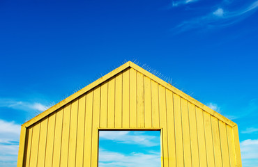 Yellow open wooden gate, wall leading to beautiful sky. Gate to nature