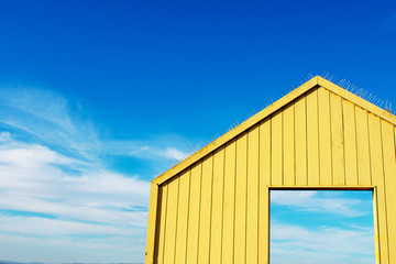 Yellow open wooden gate, wall leading to beautiful sky. Gate to nature