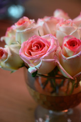 pink roses in clear vase with bokeh