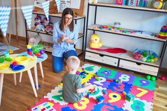 Young therapist woman speaking with child, counselor and behaviour correction at the office around toys