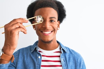 Young african american man eating sushi using chopsticks over isolated white background with a happy face standing and smiling with a confident smile showing teeth