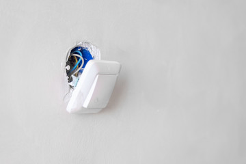 a broken electric switch on a white wall