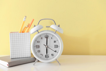 Alarm clock with stationery on table