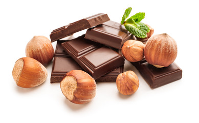 Tasty chocolate with hazelnuts on white background