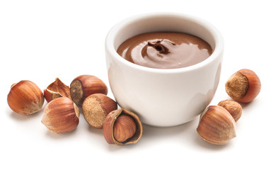 Tasty chocolate paste with hazelnuts on white background