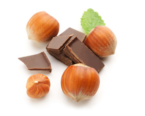 Tasty chocolate with hazelnuts on white background