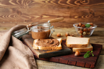 Fresh bread with tasty chocolate paste on table