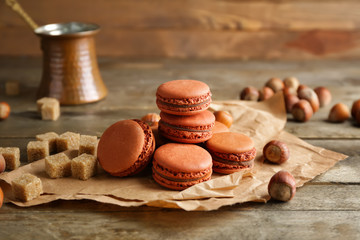 Tasty macarons with hazelnuts on table