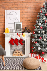 Christmas socks with gifts hanging on fireplace in interior of room