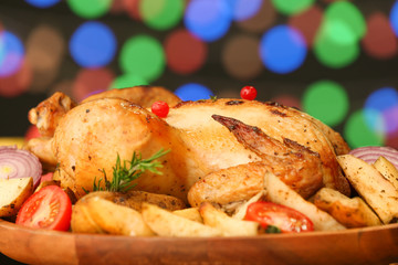 Tasty baked turkey with vegetables for Thanksgiving day on table against blurred lights