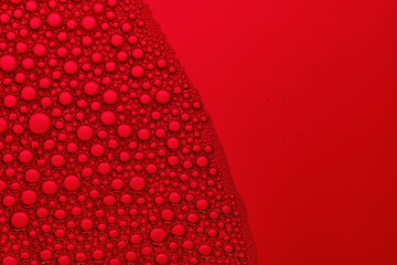 Abstract red background with soap bubbles in the water. Foam in high magnification. Close-up. Macro.