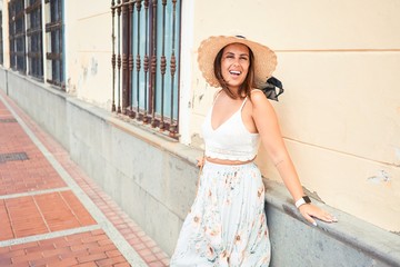 Young beautiful woman on romatic village leaning on the of the town street on a sunny day