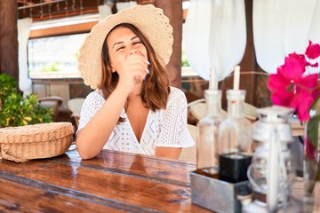 Young beautiful woman sitting at tropical restaurant enjoying summer vacation