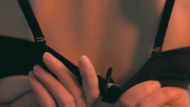Close up of young woman who taking off her black bra