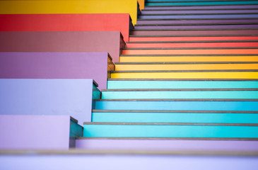 Young boy jumping on the stair rainbow colorful