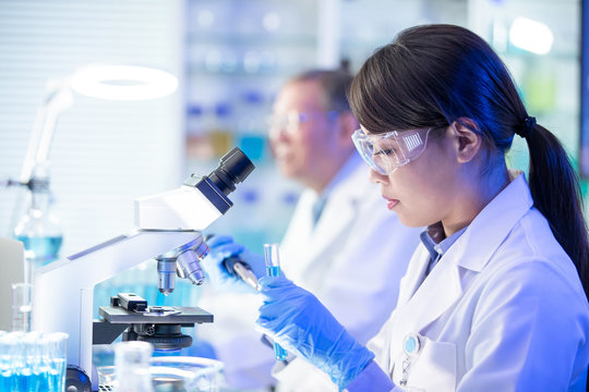 Asian scientist use microscope