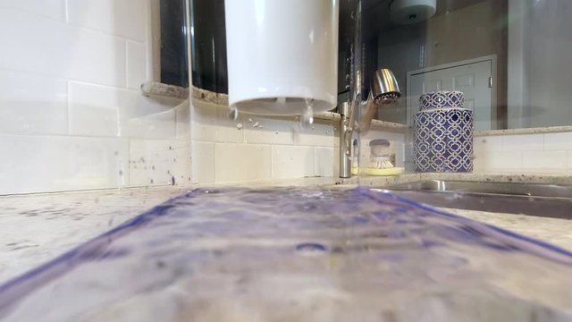 POV from inside water filtration container filtering drinking water. Dripping from gravity filter