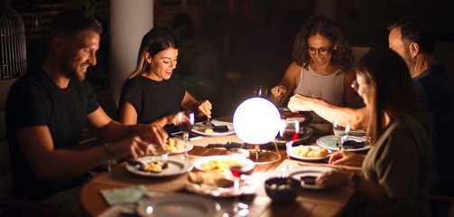 Beautiful family on dinner talking and smiling at terrace