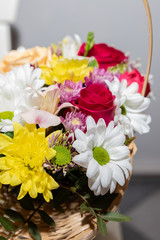 Colorful ornamental variety of flowers in the gift wood basket with roses , leaf and chrysanthemum, daisies,selective focus.flower arrangement. spring bouquet for holidays.