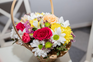 Colorful ornamental variety of flowers in the gift wood basket with roses , leaf and chrysanthemum, daisies,selective focus.flower arrangement. spring bouquet for holidays.