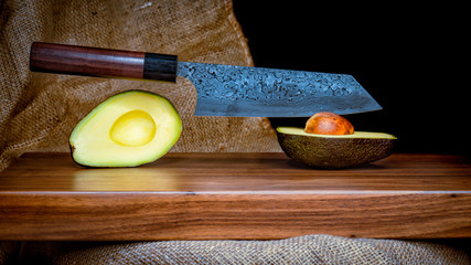 ein Messer steckt in einer aufgeschnittenen Avocado 