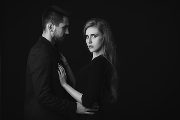 elegant couple in the tender passion. man embracing beautiful woman in black dress. black and white