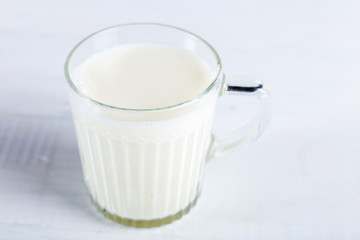 Glass of milk on wooden background.