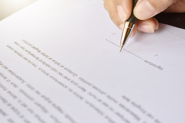 hand with pen signing contract, sign documents