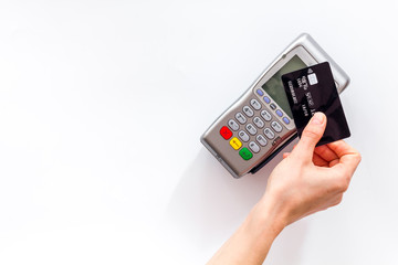 Contactless payment, paypass. Hand hold bank card near terminal on white background top-down copy space