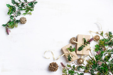 Australia native inspired Christmas background with gifts. Gold presents, ribbons and baubles surrounded by Australian native Christmas foliage Grevillea on a rustic white background.