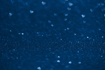 Abstract macro shot of blue glittering paper with hearts bokeh. Valentine's Day and love or Christmas concept. Banner, postcard, backgrounds. Copy space. Love is all around. 