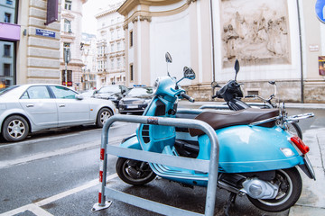 blue scooter moped parked at city street side