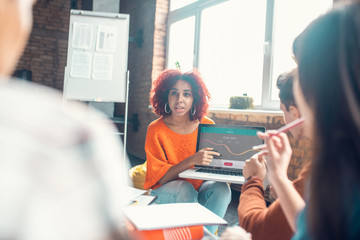 Student speaking with friends while presenting her project