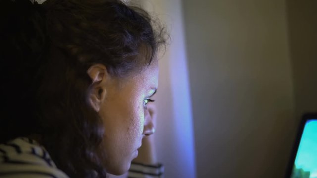 Teen girl surfing on internet, screen light reflection on her face